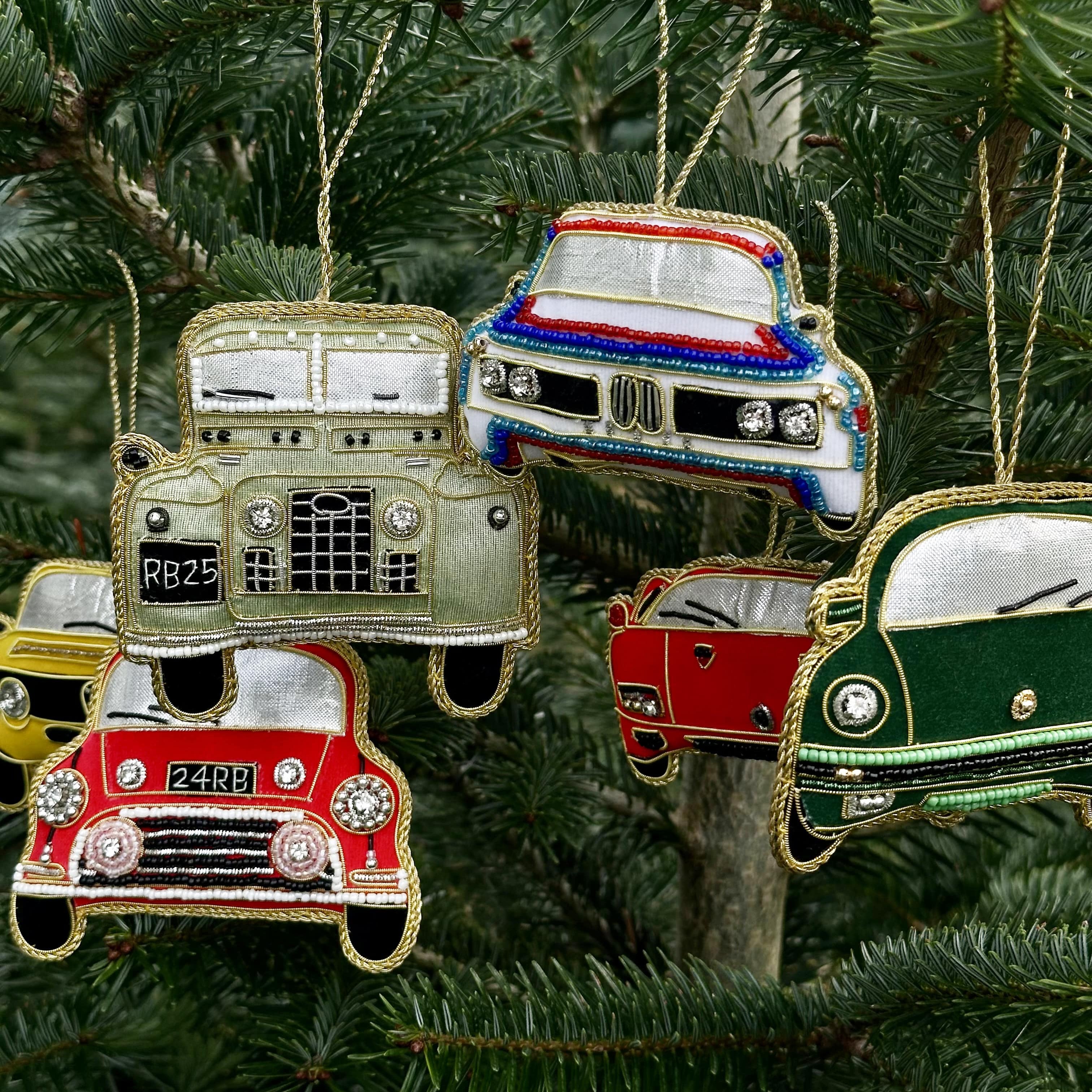 Decorative car ornaments hanging on a Christmas tree.