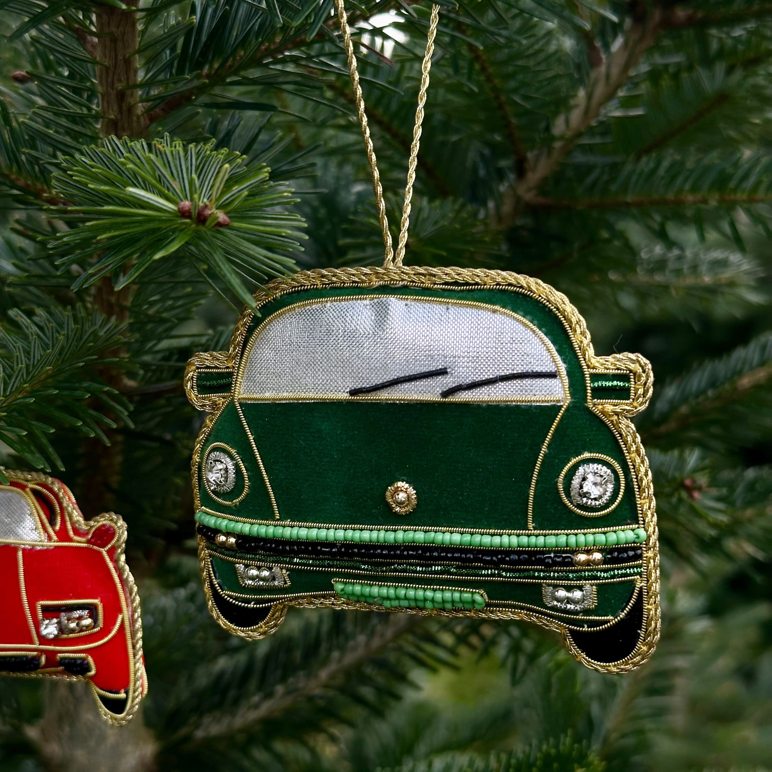 Green car ornament hanging on a Christmas tree