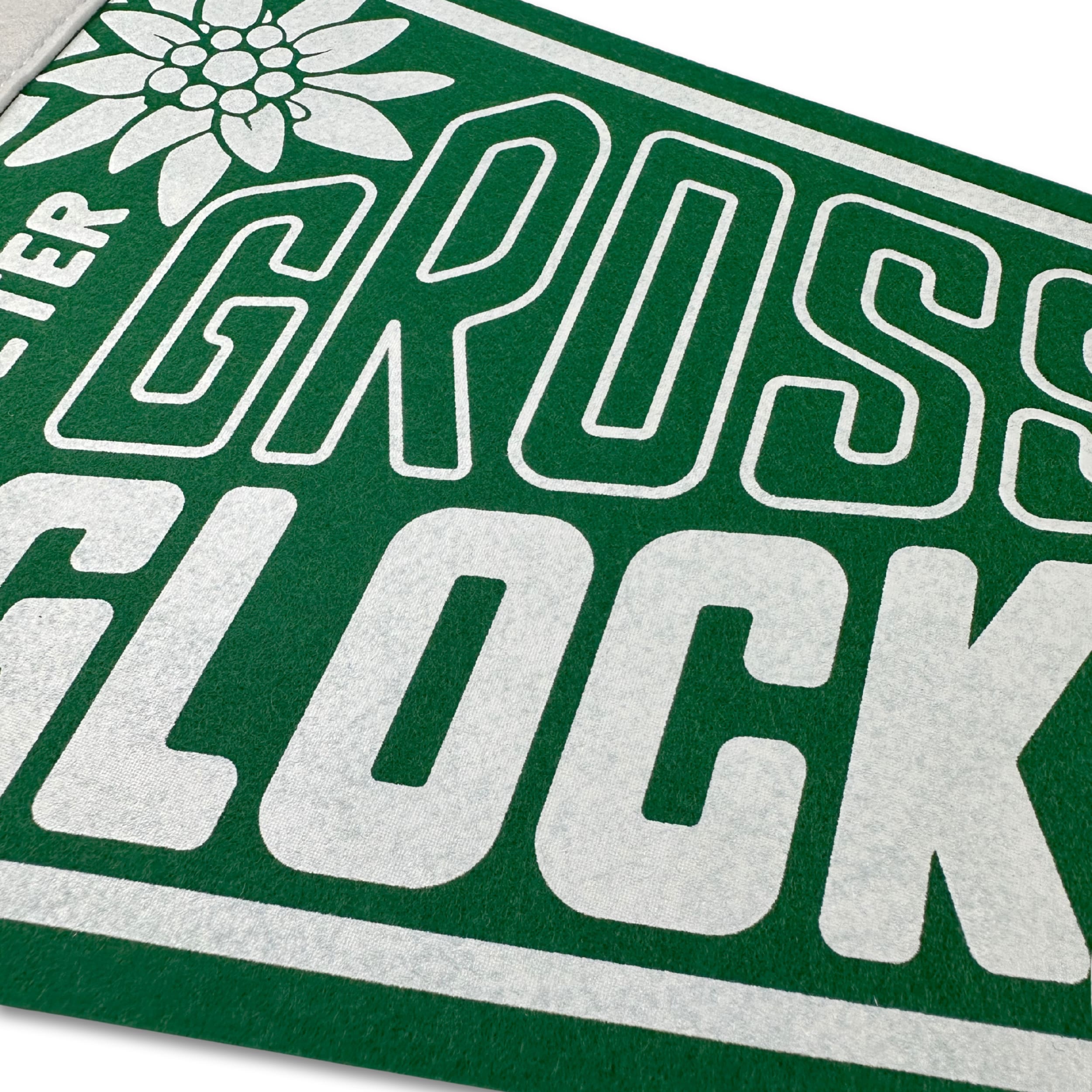 Close-up of a green and white label with 'Gross Glock' text on a white background