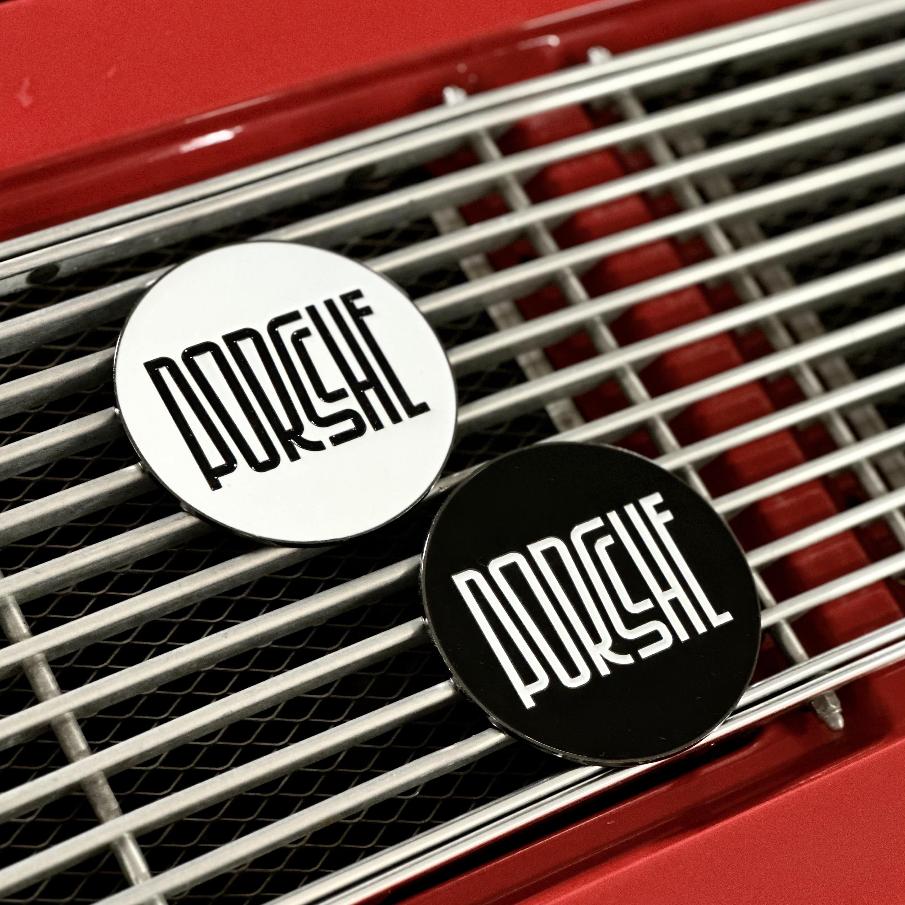 rennbetrieb white and black enamel badge on red porsche