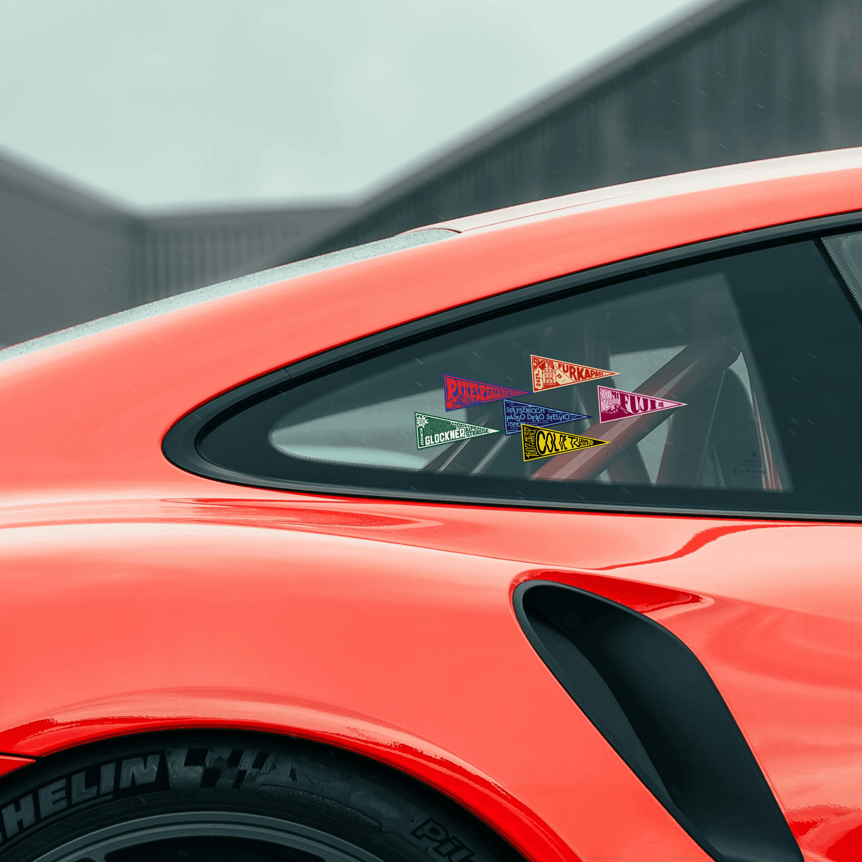 Close-up of a red car with colorful stickers on the window